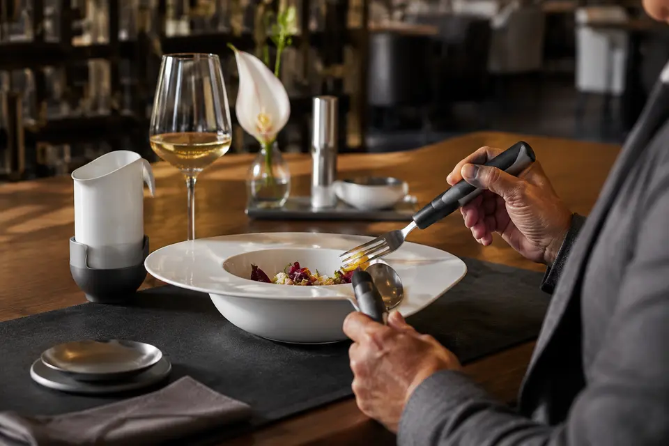 Adaptive dinnerware and ergonomic utensils in a refined hotel restaurant