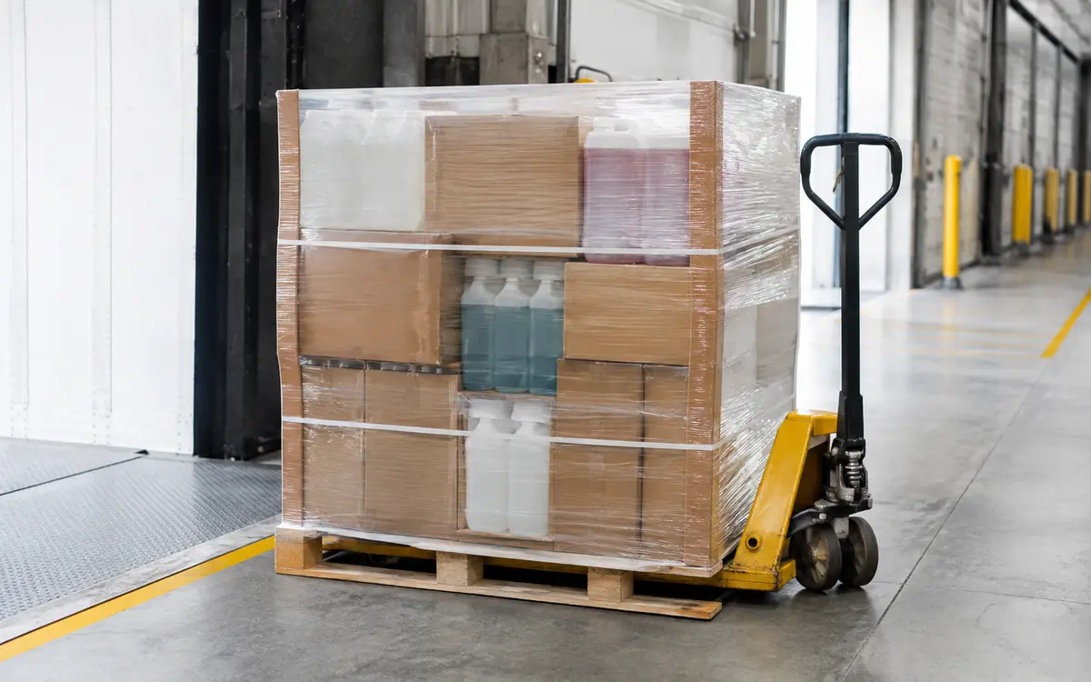 Consolidated pallet of hospitality cleaning chemicals prepared for delivery