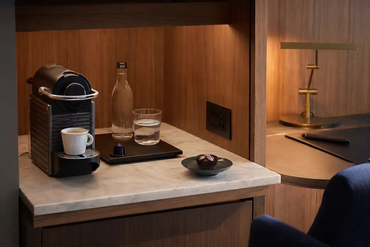Executive hotel capsule coffee setup with espresso, water, and chocolate