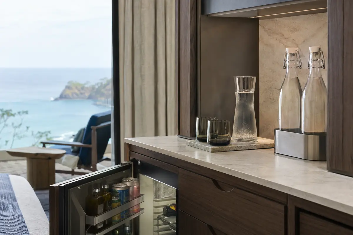 Refillable hotel water system with sealed glass bottles and reusable cups