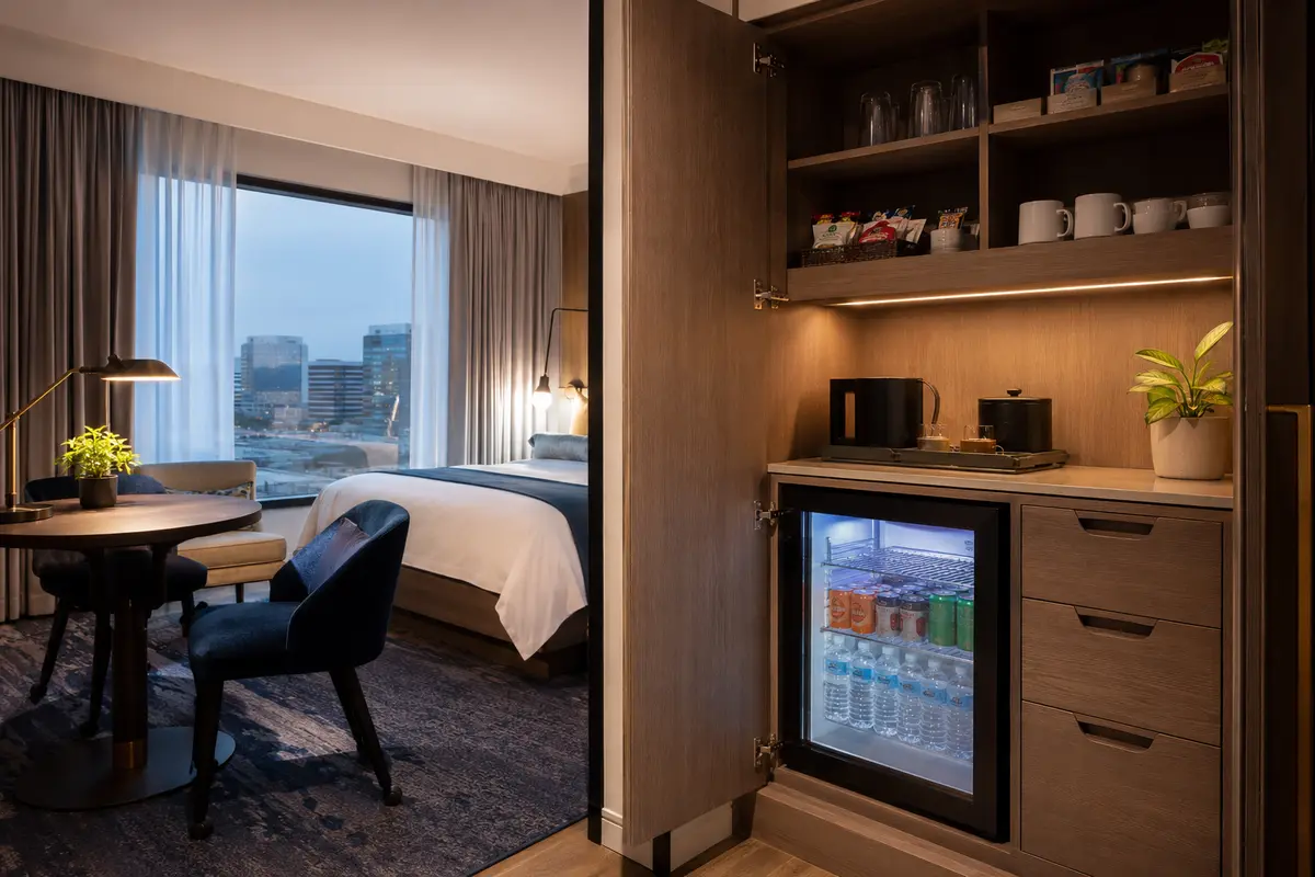 Extended-stay hotel pantry cabinet with minibar refrigerator and beverage supplies