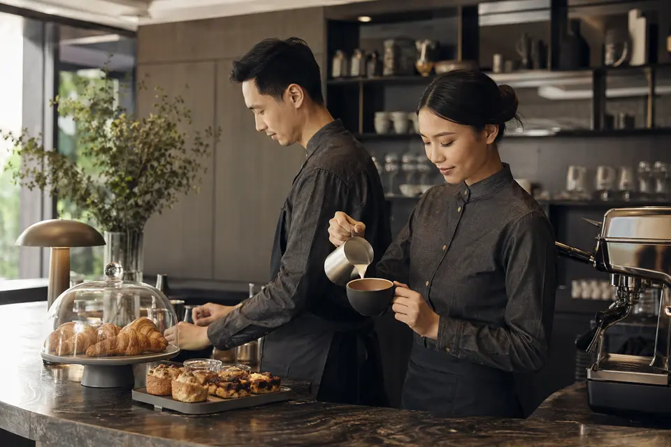Hotel cafe staff in coordinated contemporary uniforms